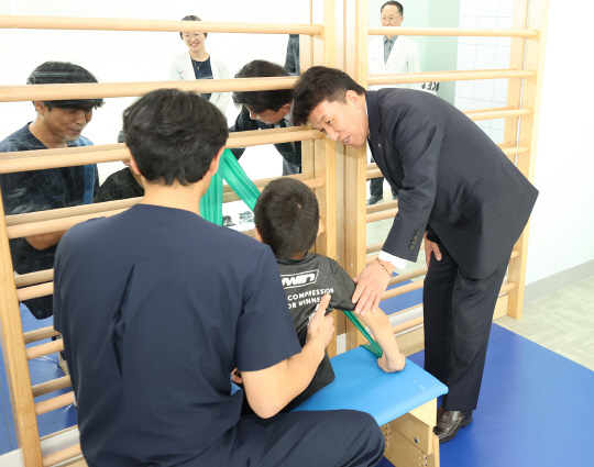 함영주(오른쪽) 하나금융그룹 회장이 중추신경계 발달치료를 받고 있는 장애 아동에게 따뜻한 격려의 말을 전하고 있다. [하나금융그룹 제공]